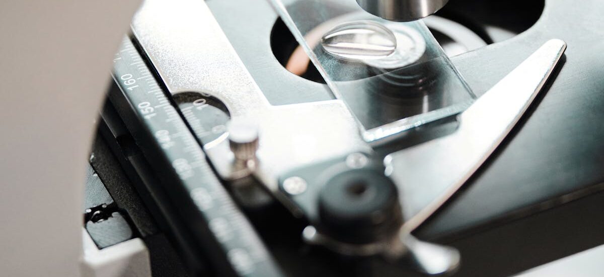 Detailed close-up view of a microscope examining a slide with precision instruments.