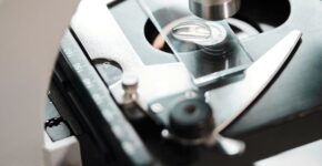 Detailed close-up view of a microscope examining a slide with precision instruments.