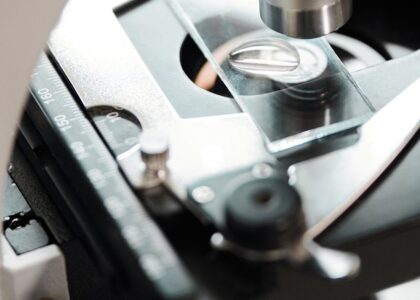 Detailed close-up view of a microscope examining a slide with precision instruments.