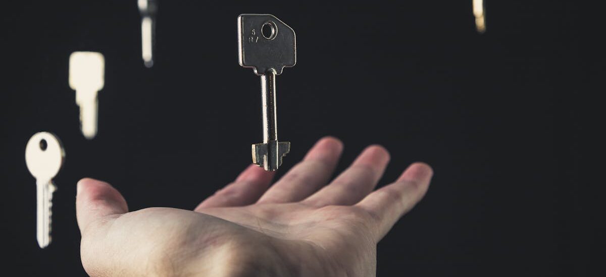 A mysterious scene of keys floating above an open hand against a dark background.