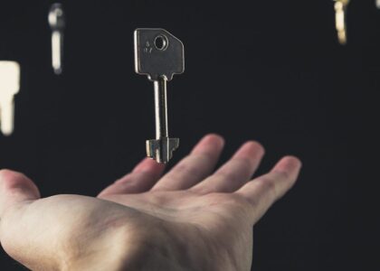 A mysterious scene of keys floating above an open hand against a dark background.