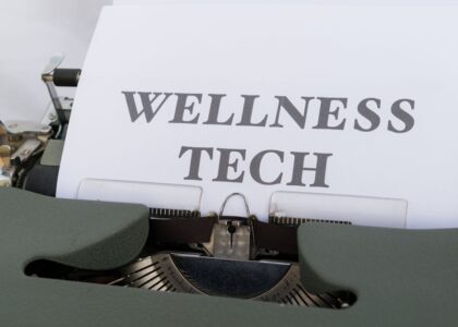 A close-up of a vintage typewriter featuring a paper with the words 'Wellness Tech.'
